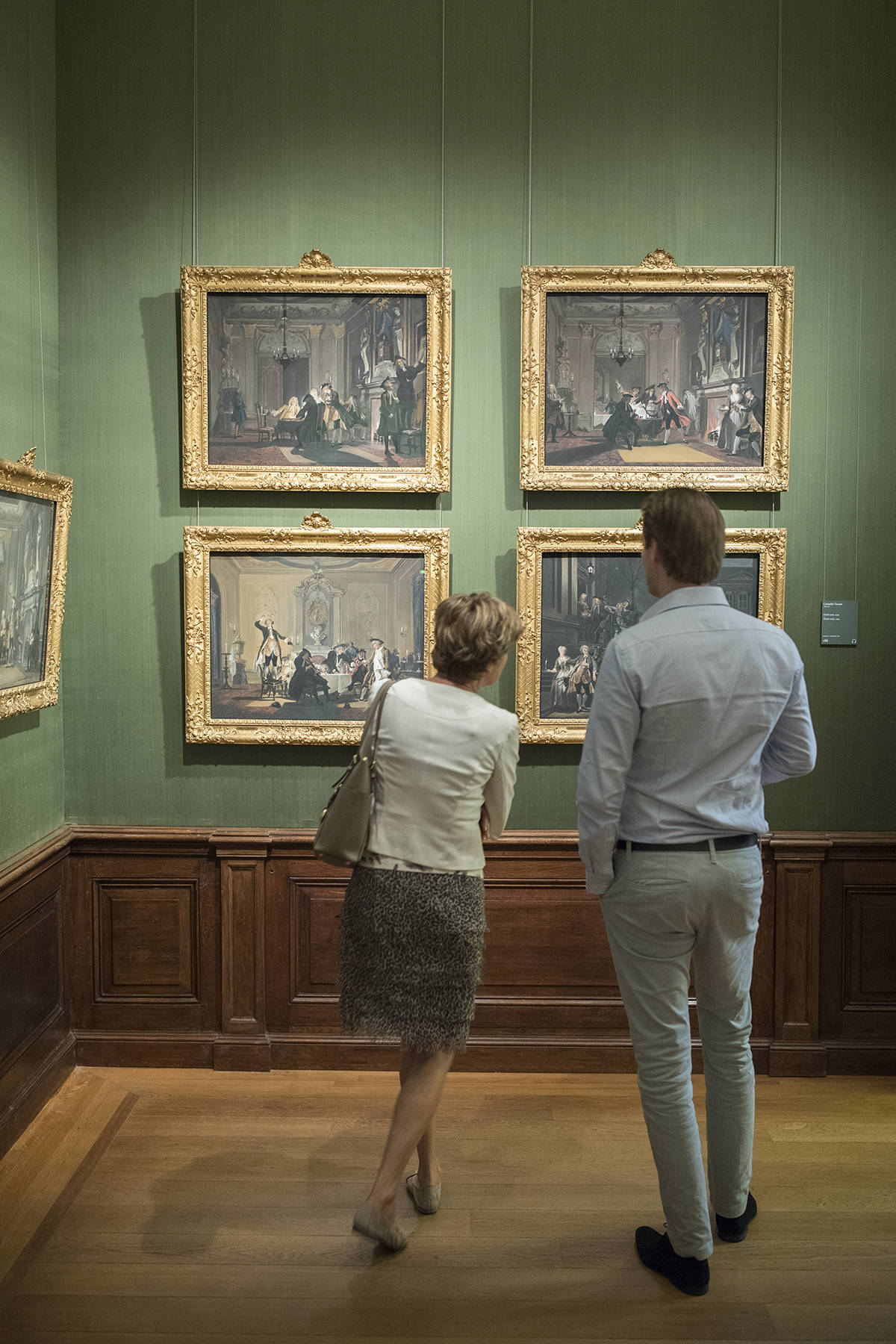 Bezoekers kijken naar de schilderijen van Cornelis Troost in het Mauritshuis in Den Haag.