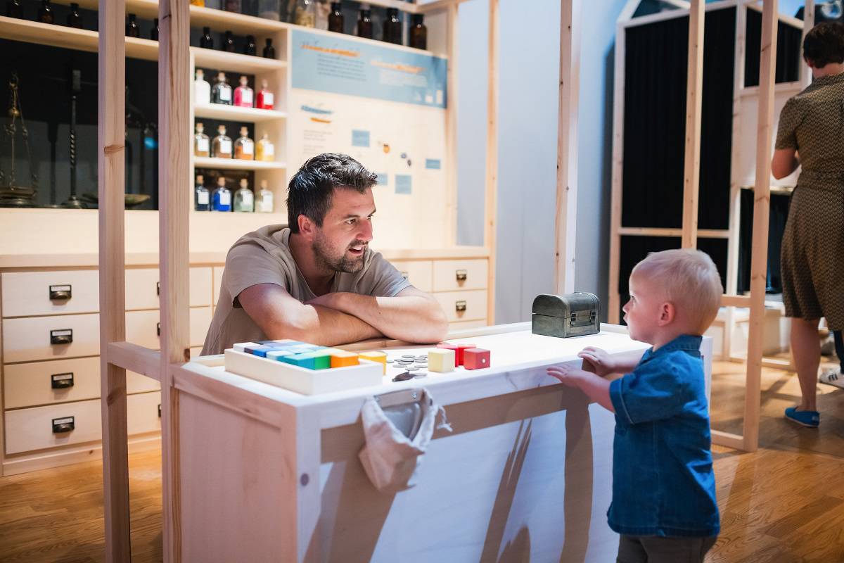 Ouder en kind spelen in de apotheek tijdens Hallo Vermeer.