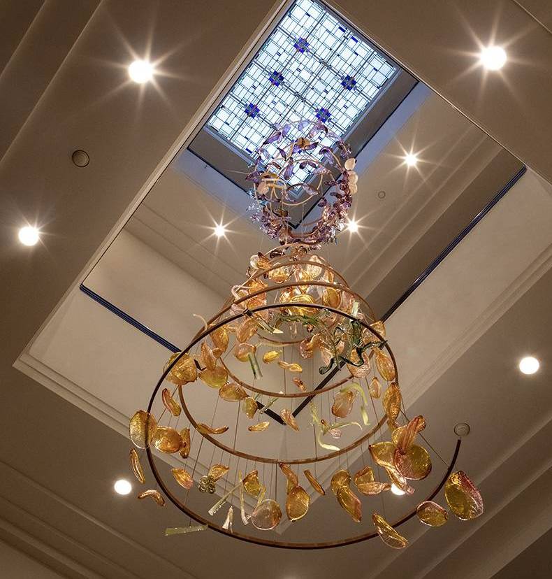 Het glaskunstwerk van kunstenaar Bibi Smit straalt in het atrium van het Mauritshuis.