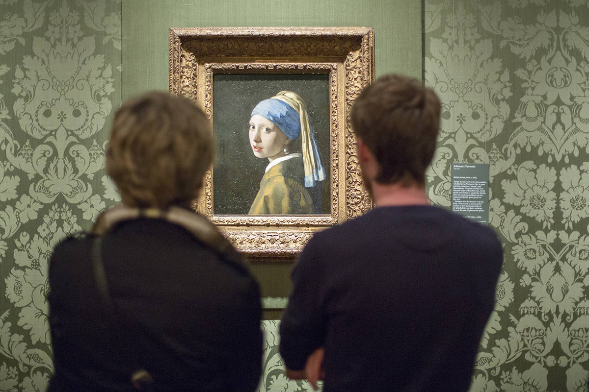 Bezoekers kijken naar het Meisje met de parel van Johannes Vermeer in het Mauritshuis, Den Haag.