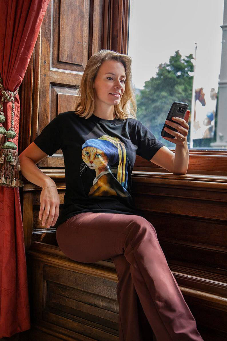 Een bezoeker draagt het t-shirt Kat met de parel uit de winkel van het Mauritshuis.