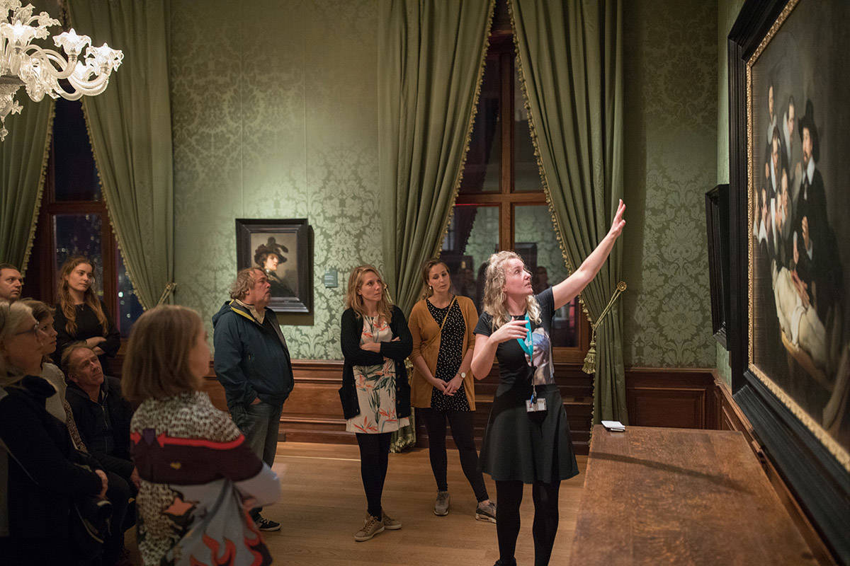 Een museumdocent vertelt deelnemers aan een rondleiding alles over 'De anatomische les' van Rembrandt.