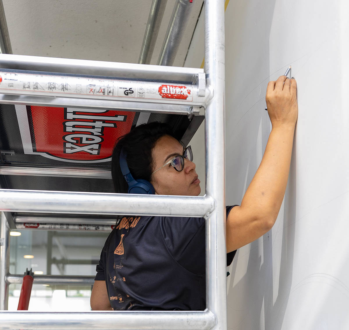 Daiara Tukano maakt een schets voor haar mural bij de ingang van het Mauritshuis in Den Haag.