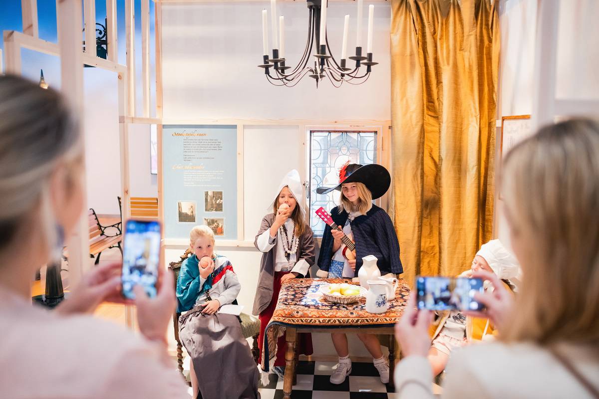 Kinderen verkleden zich in de tijdsgeest van Vermeer, twee bezoekers maken een foto.