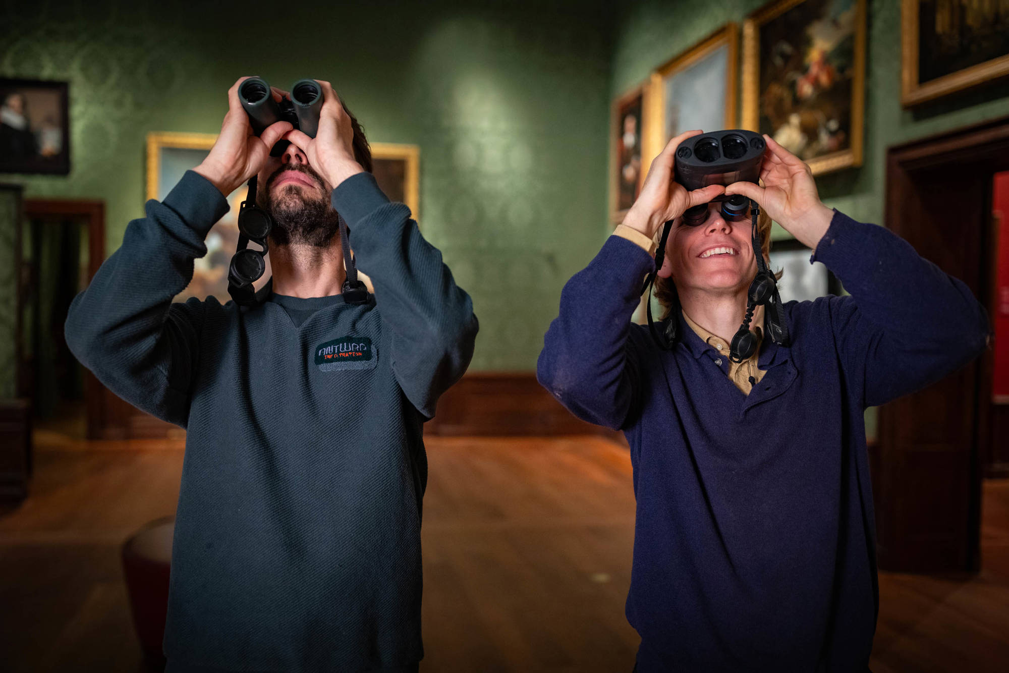 Vogelspotters Arjan en Gisbert kijken met verrekijkers naar vogels in het Mauritshuis.