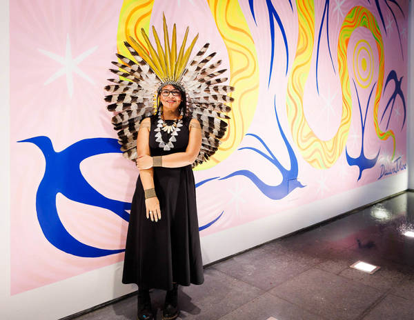 Daiara Tukano staat bij haar mural bij de ingang van het Mauritshuis in Den Haag.