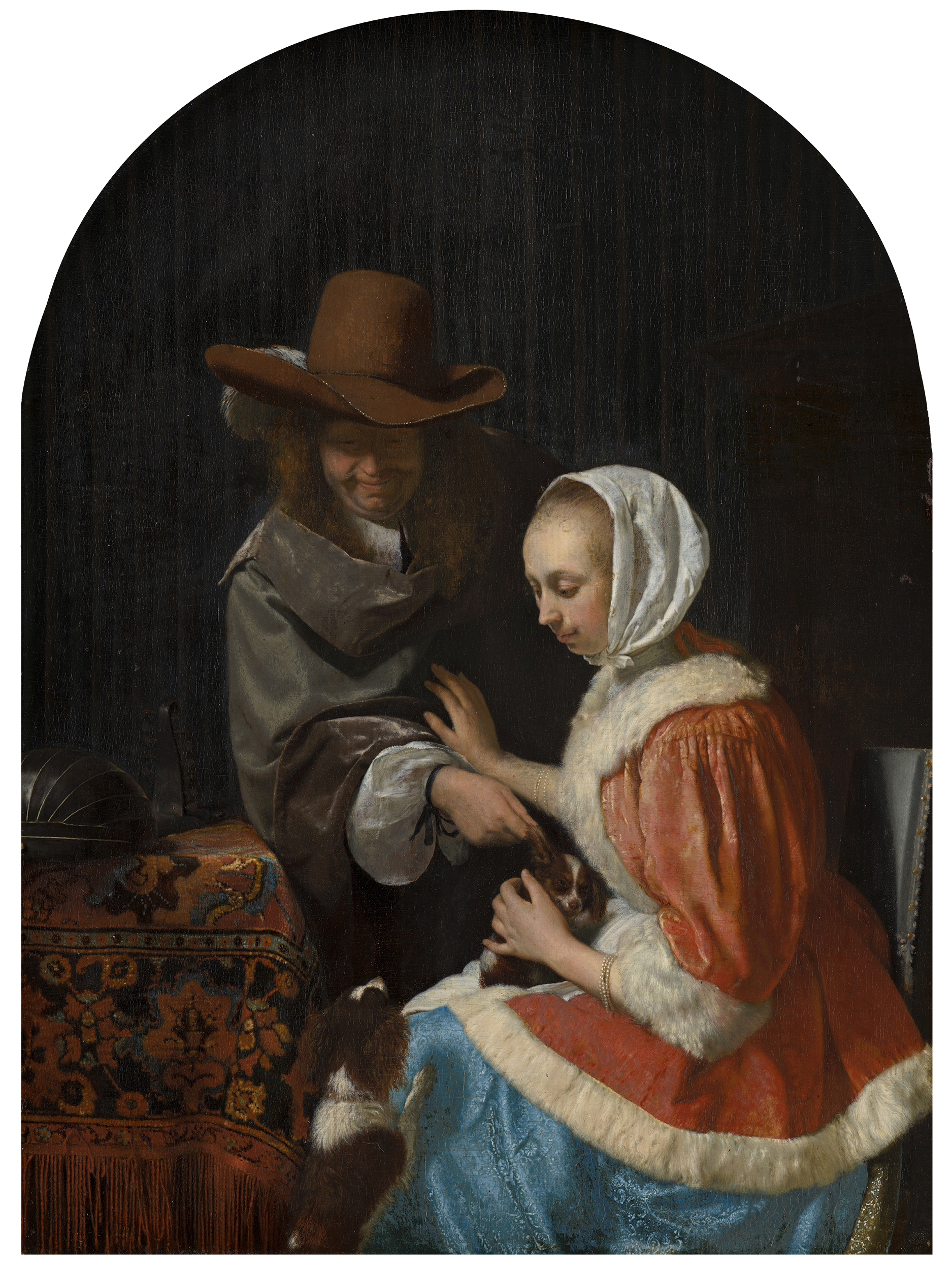 We zien hier een man die een schoothondje plagerig aan zijn oor probeert te trekken, maar de vrouw weert hem af.