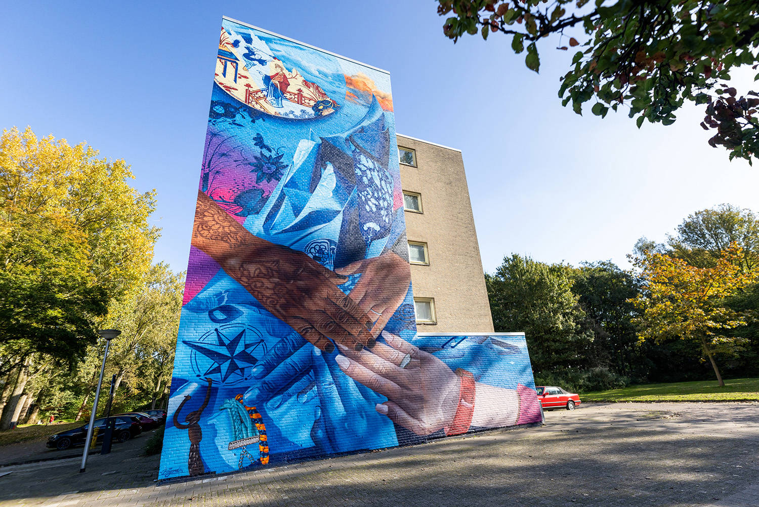 BEYOND liet zich voor deze mural inspireren door het Museum Prinsenhof. Zijn werk zit op de rand van realisme en abstract. We zien handen van verschillende huidskleuren die elkaar vasthouden.