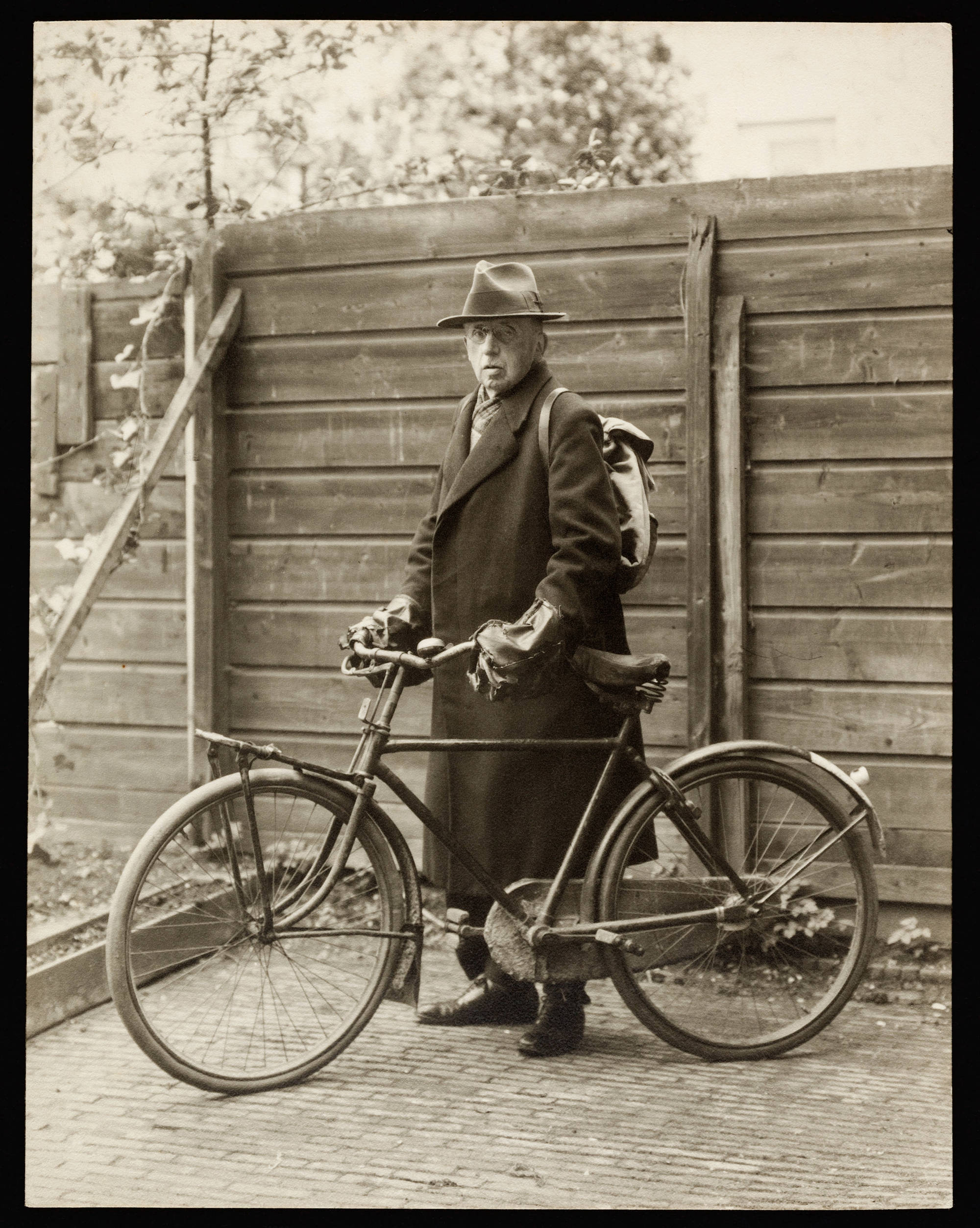 Directeur Wilhelm Martin met zijn fiets. De foto is in sepia.
