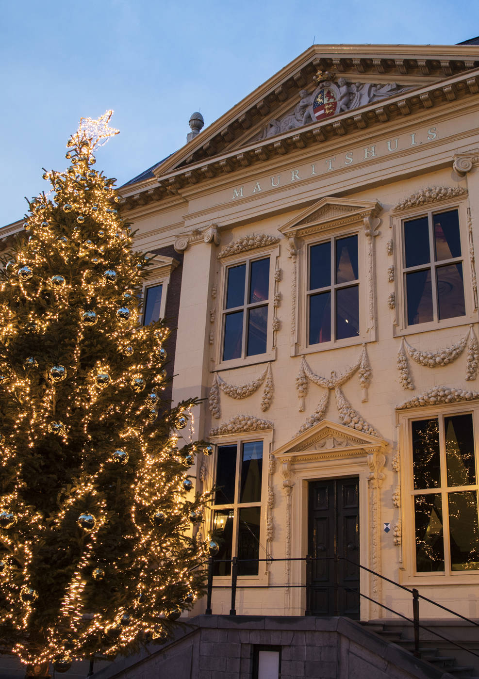 Een sfeervol verlichte kerstboom staat op het voorplein van museum het Mauritshuis in Den Haag