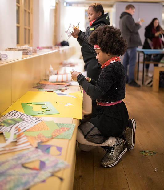 Een kind is lekker aan het knutselen in de ontvangstruimte van Galerij Prins Willem V.
