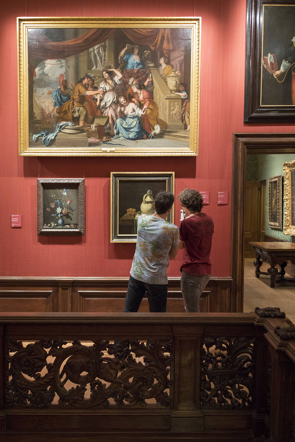 Twee bezoekers kijken aandachtig naar schilderijen in het Mauritshuis in Den Haag.
