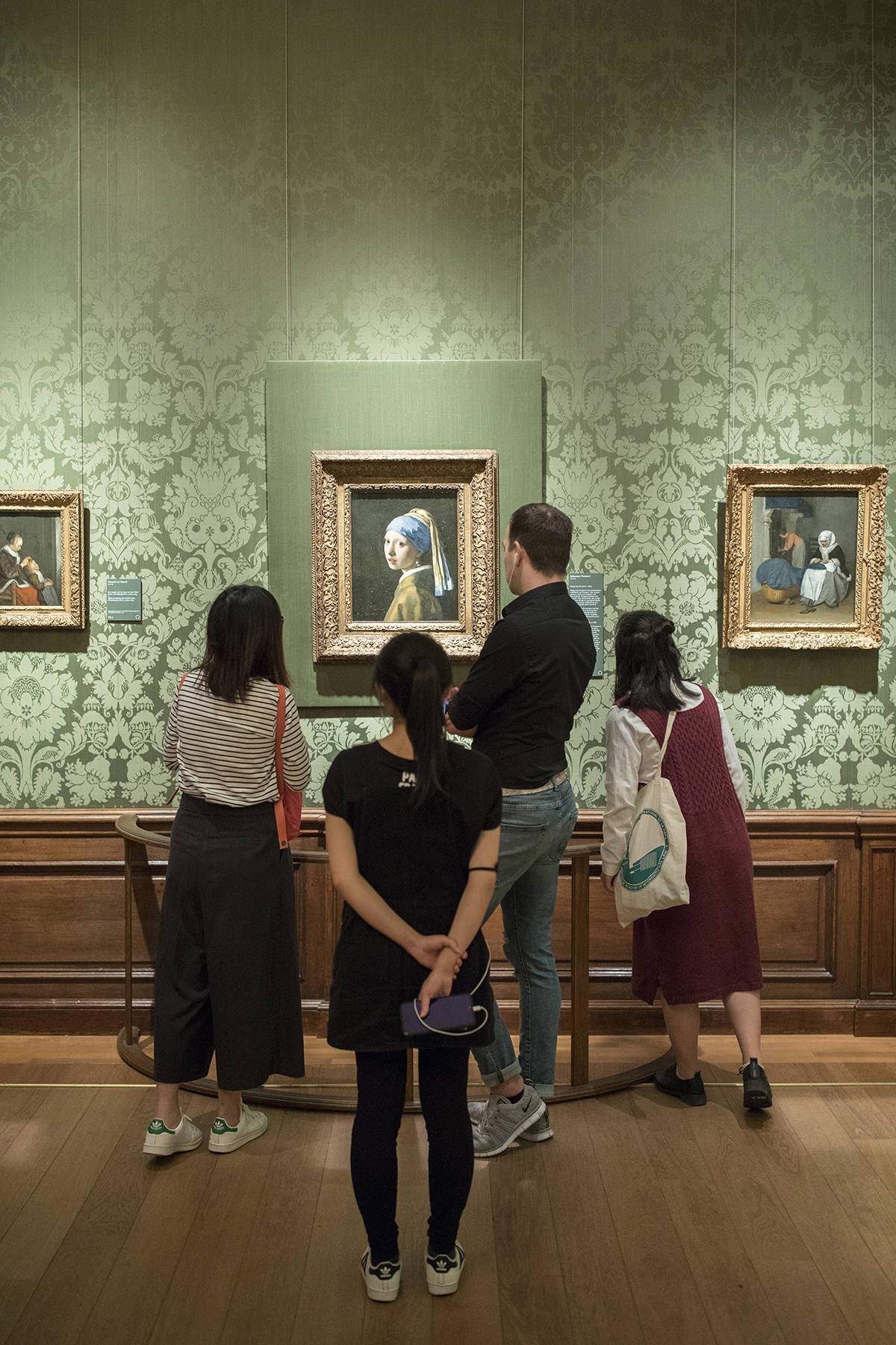 Visitors of the museum look at Vermeers Girl With A Pearl Earring at Museum Mauritshuis in The Hague.