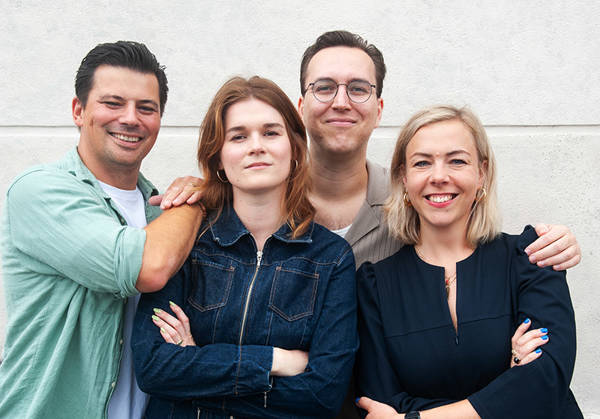 Alle geschiedenis ooit teamleden naast elkaar voor een witte muur