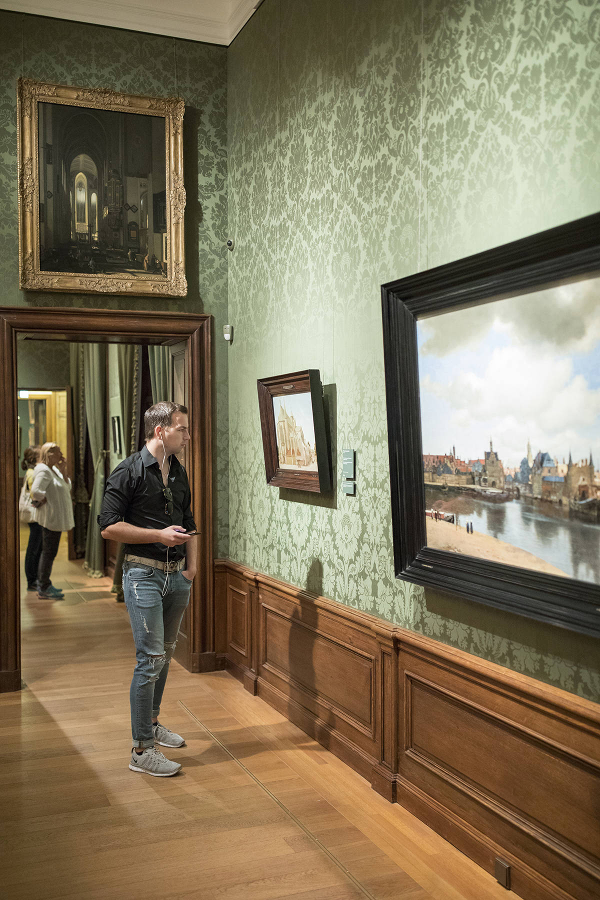 A visitor does the multimediatour and looks at View of Delft by Vermeer at the Mauritshuis in The Hague.