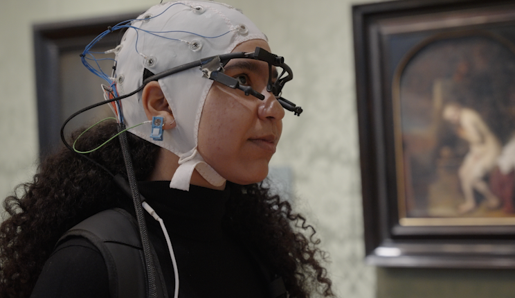 Een respondent kijkt met een EEG en eyetracker op naar het Meisje met de Parel van Vermeer in het Mauritshuis, in Den Haag.