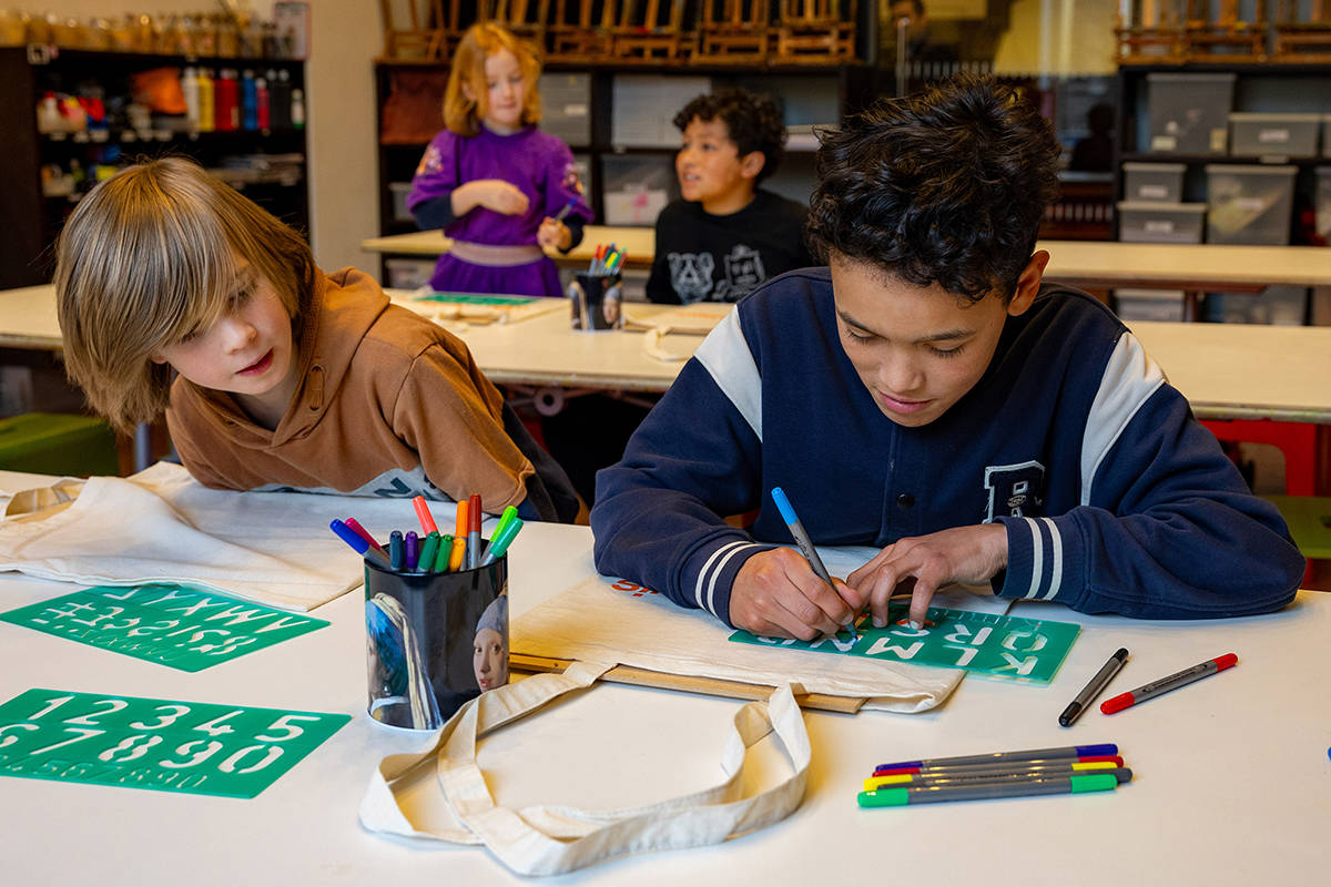 Vier kinderen zijn lekker aan het knutselen in de Kunstwerkplaats van het Mauritshuis.