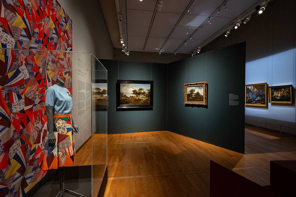 Overzicht van de tentoonstellingszaal Huis in de Storm in het Mauritshuis. Er staan o.a. een bevrijdingsrok en schilderijen op.