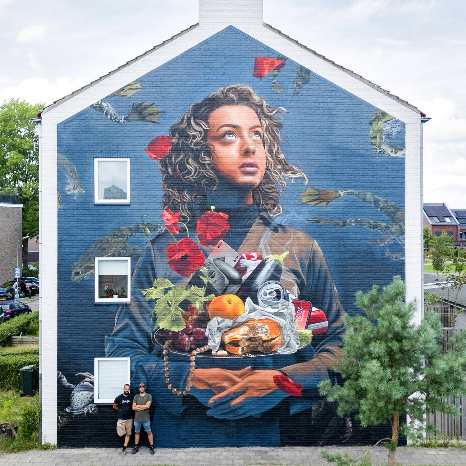 Studio Giftig liet zich inspireren door het Noordbrabants Museum. Twee mannen leunen tegen hun mural aan de zijkant van een appartementencomplex.