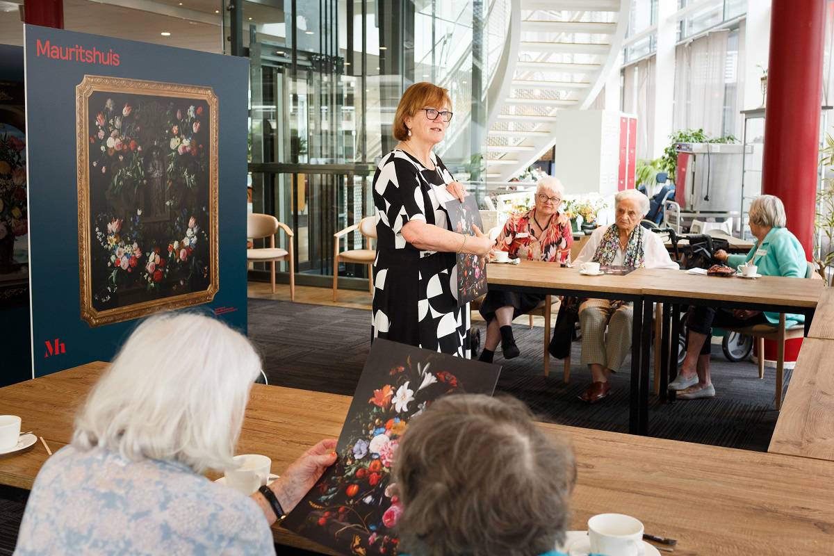 Een museumdocent neemt deelnemers aan 'Onvergetelijk' mee langs de collectie van het Mauritshuis.