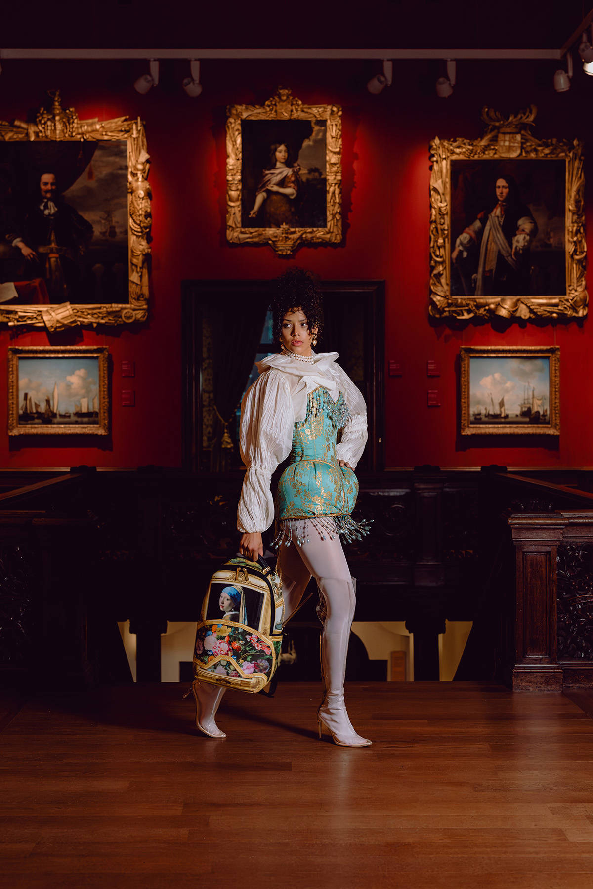 Een model poseert in de trapzaal van het Mauritshuis met een tas van Sprayground.