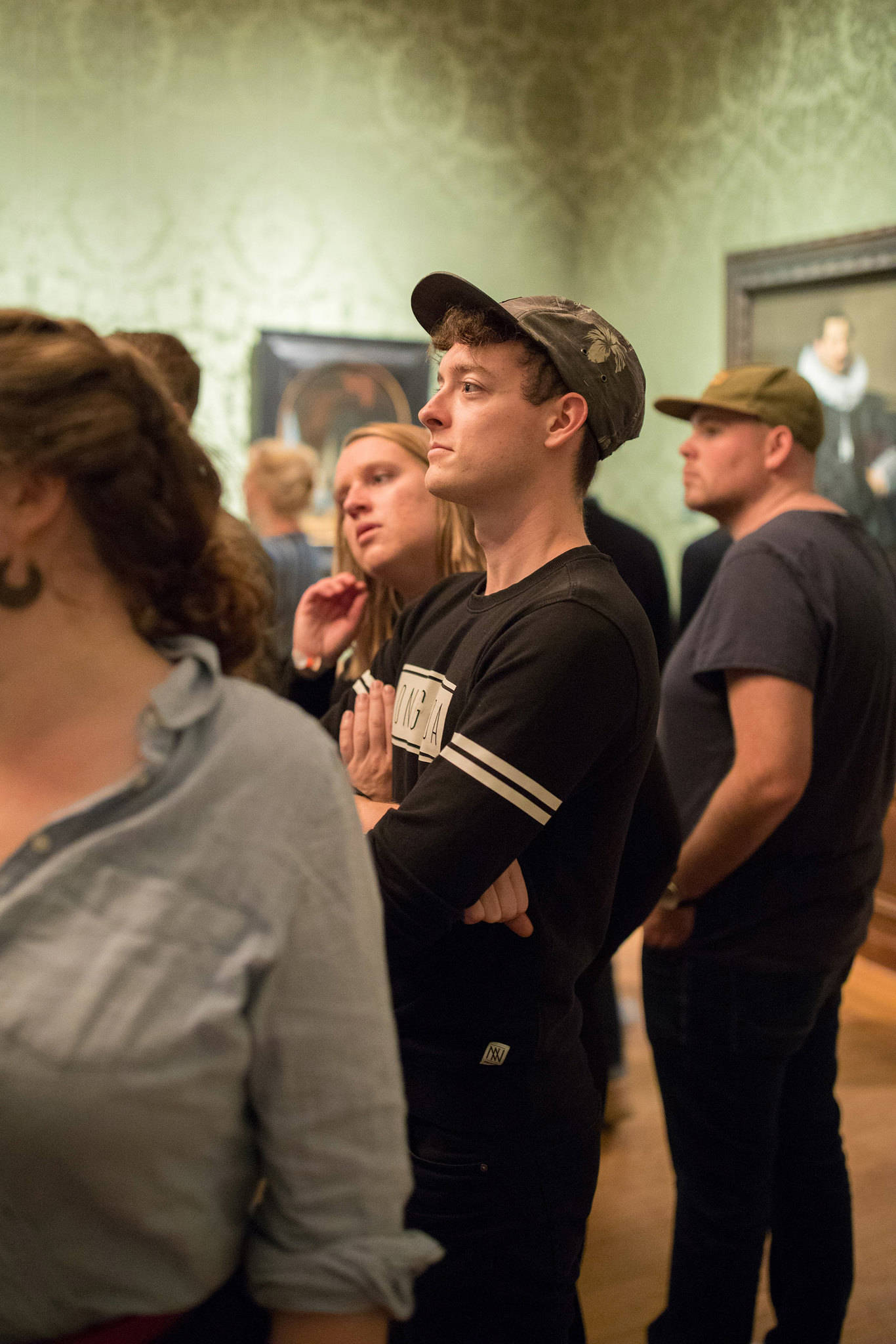 Een bezoeker luistert geboeid naar een rondleiding in het Mauritshuis.