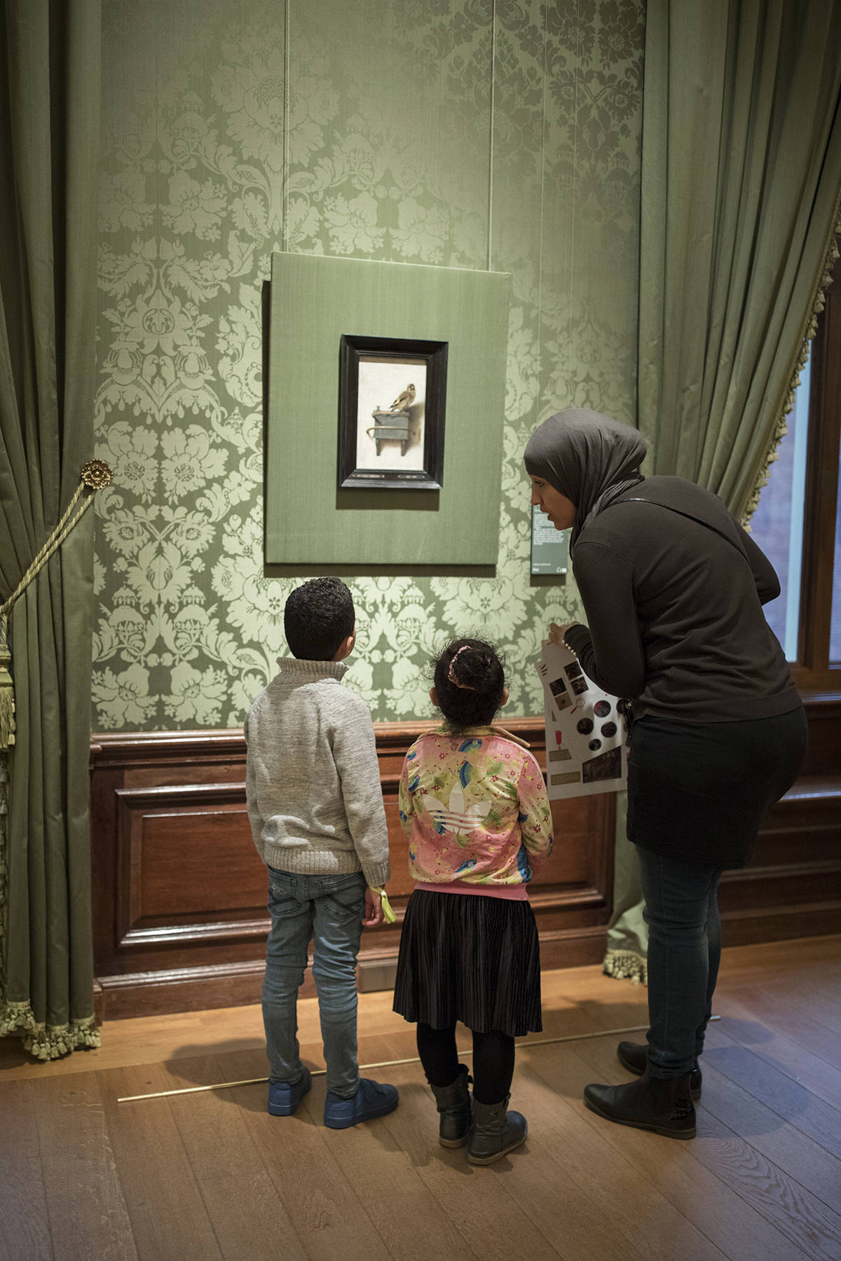 Bezoekers bekijken Het puttertje van Carel Fabritius in het Mauritshuis