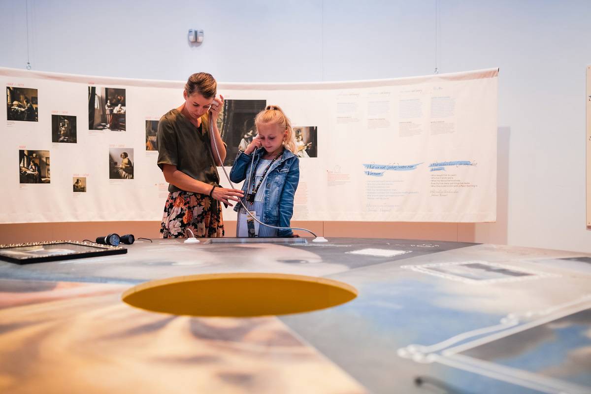 Twee bezoekers staan in de onderzoeksruimte van de tentoonstelling Hallo Vermeer.