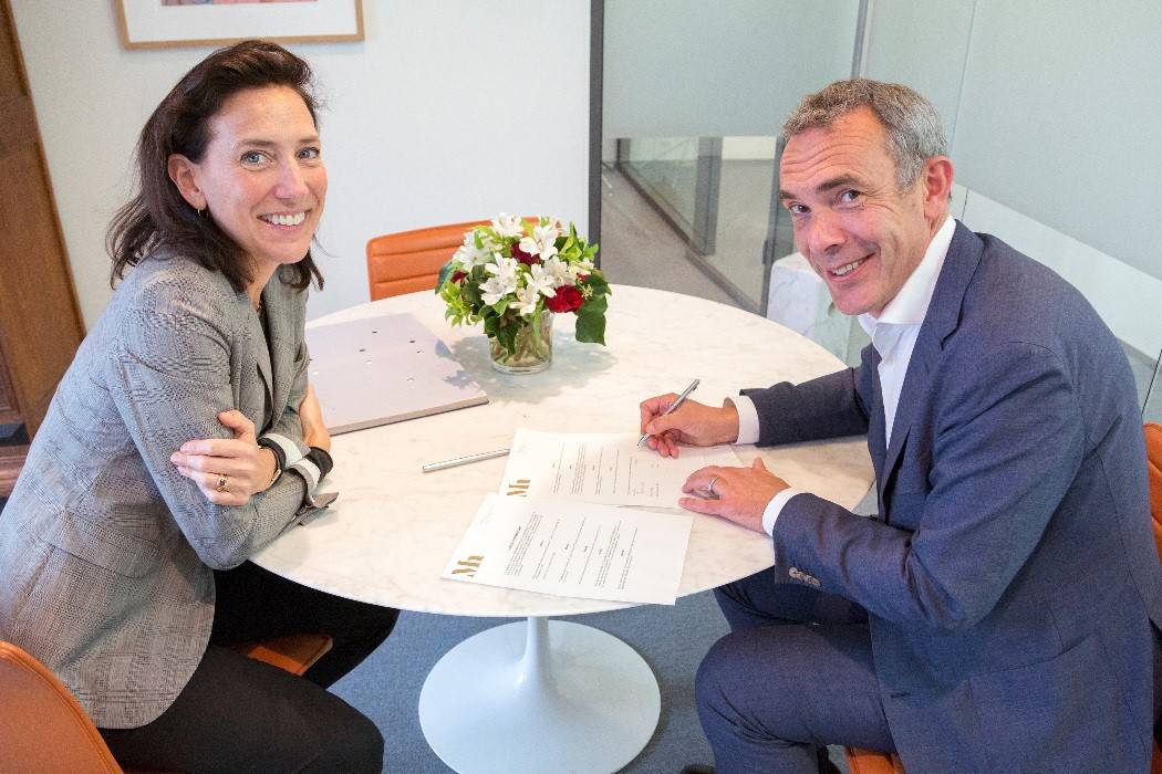 Emilie Gordenker en Sander Uitdenbogaard tekenen papieren. Foto: Ivo Hoekstra
