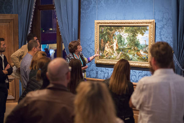 Een gids vertelt iets over het schilderij Het aardse paradijs met de zondeval van Adam en Eva tijdens de Hoogtepunten rondleiding in het Mauritshuis.