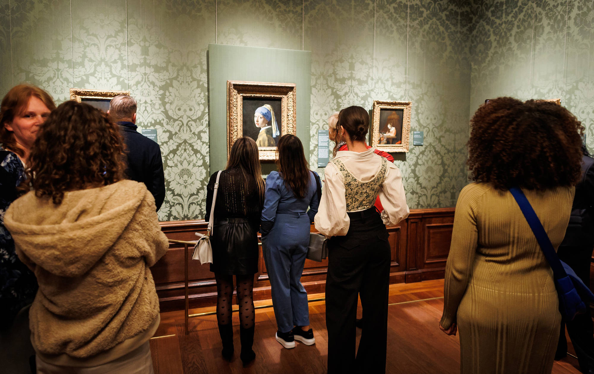 Bezoekers kijken allemaal naar Meisje met de Parel van Johannes Vermeer in het Mauritshuis.