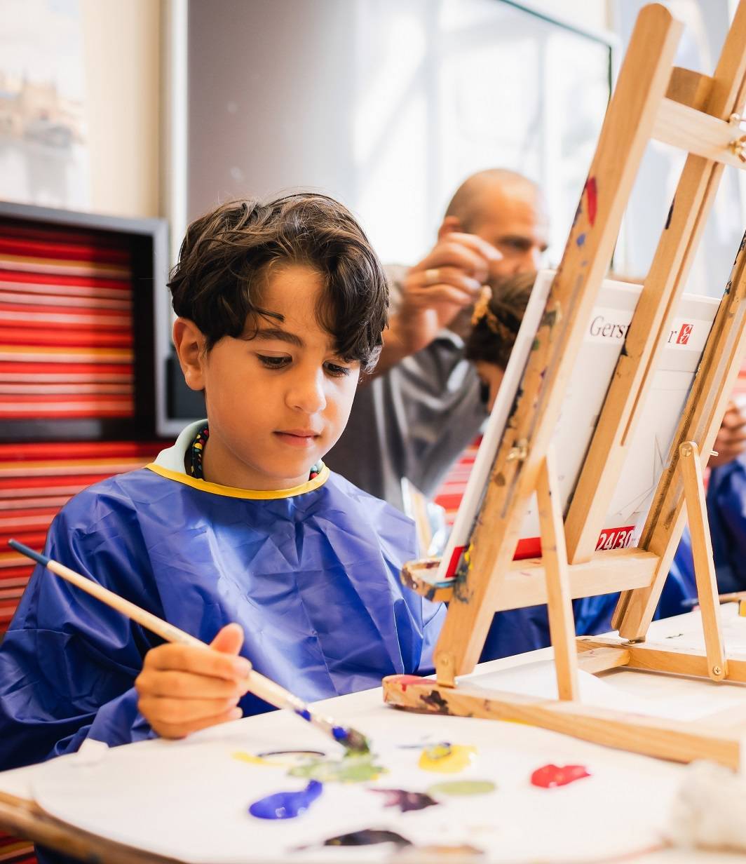 Een jongen schildert in de Kunstwerkplaats tijdens een workshop van Hallo Vermeer in het Mauritshuis.