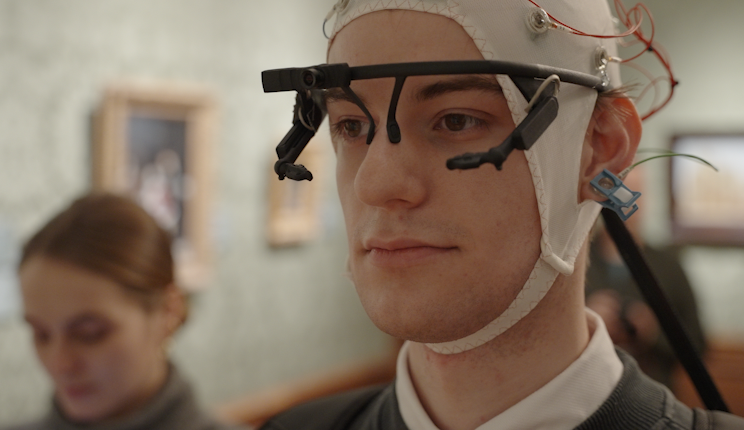 Een proefpersoon kijkt met een EEG en eyetracker op naar het Meisje met de Parel van Vermeer in het Mauritshuis, in Den Haag.