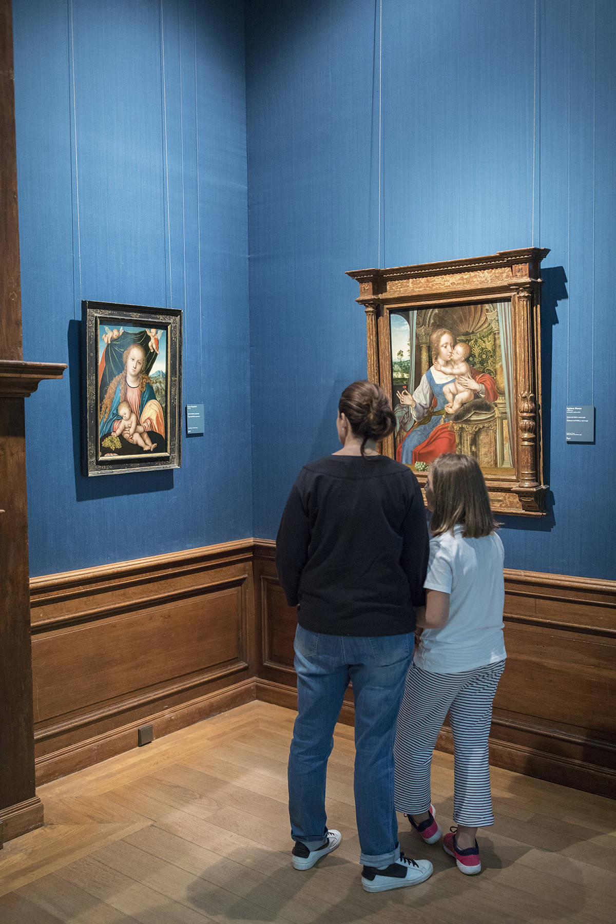 Twee bezoekers bekijken schilderijen van de oude Vlaamse meesters in het Mauritshuis in Den Haag.