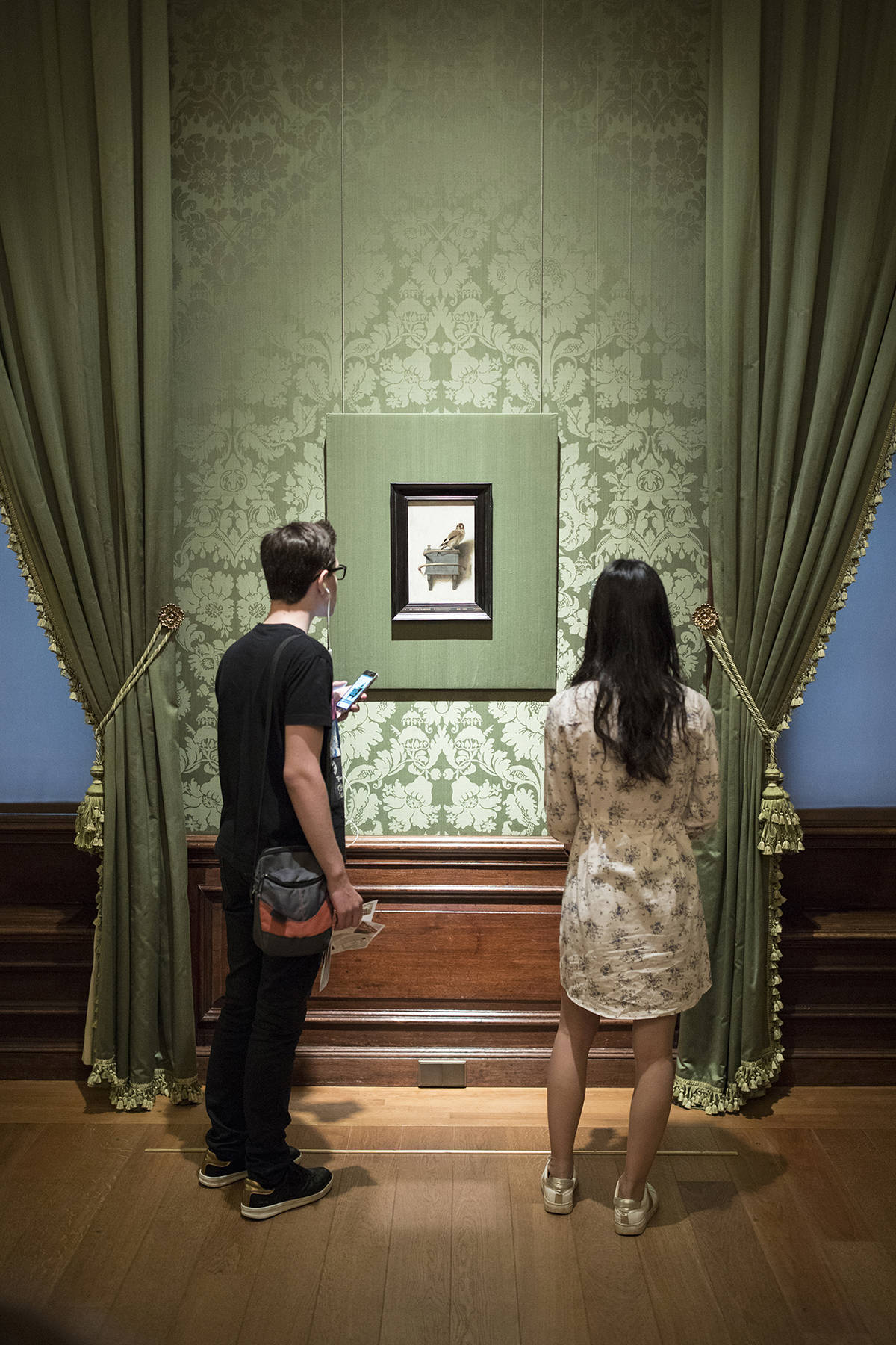 Visitors look at The Goldfinch by painter Fabritius at Museum Mauritshuis in The Hague, Netherlands.