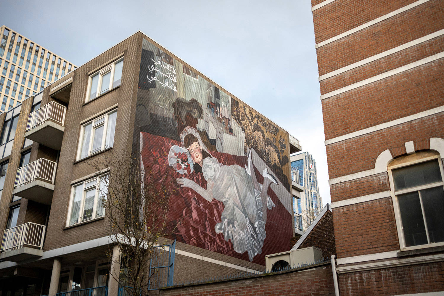 Dalal Mitwally maakte deze mural op een appartementencomplex, van een meisje in Victoriaanse kleding op een bed in haar kamer, met bloemen en een televisie in de hoek.
