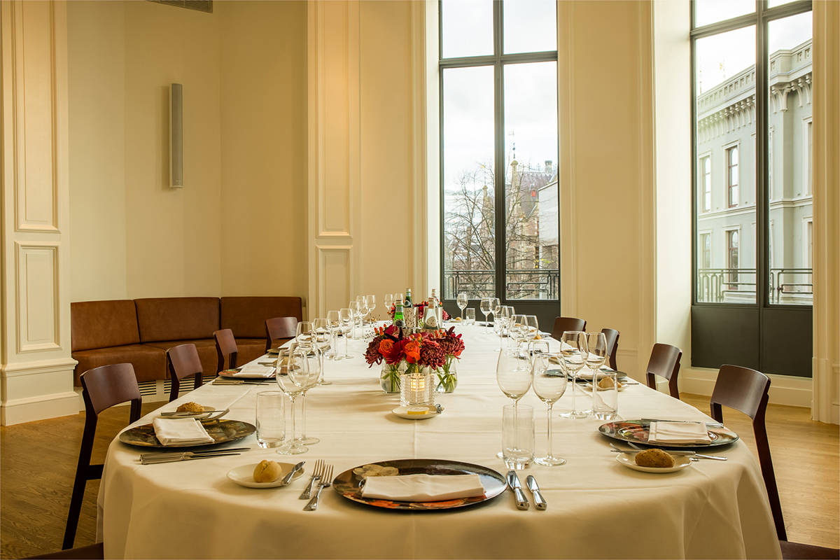 Een lange eettafel met uitzicht in het Mauritshuis